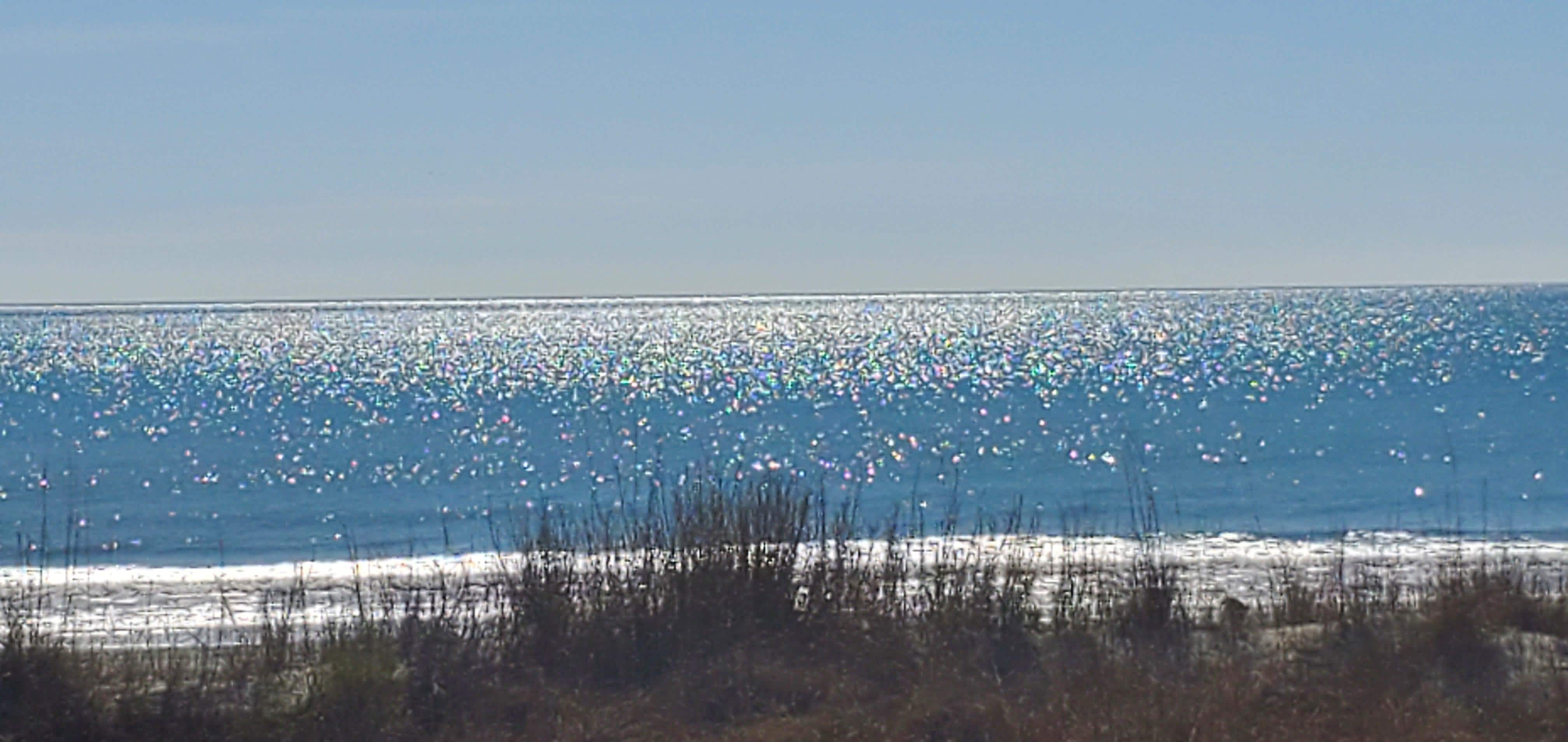 Sun glistening on water. View from deck.
