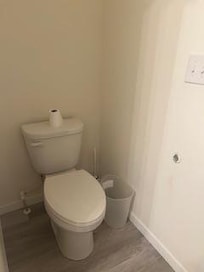 Toilet paper holder missing off the wall.