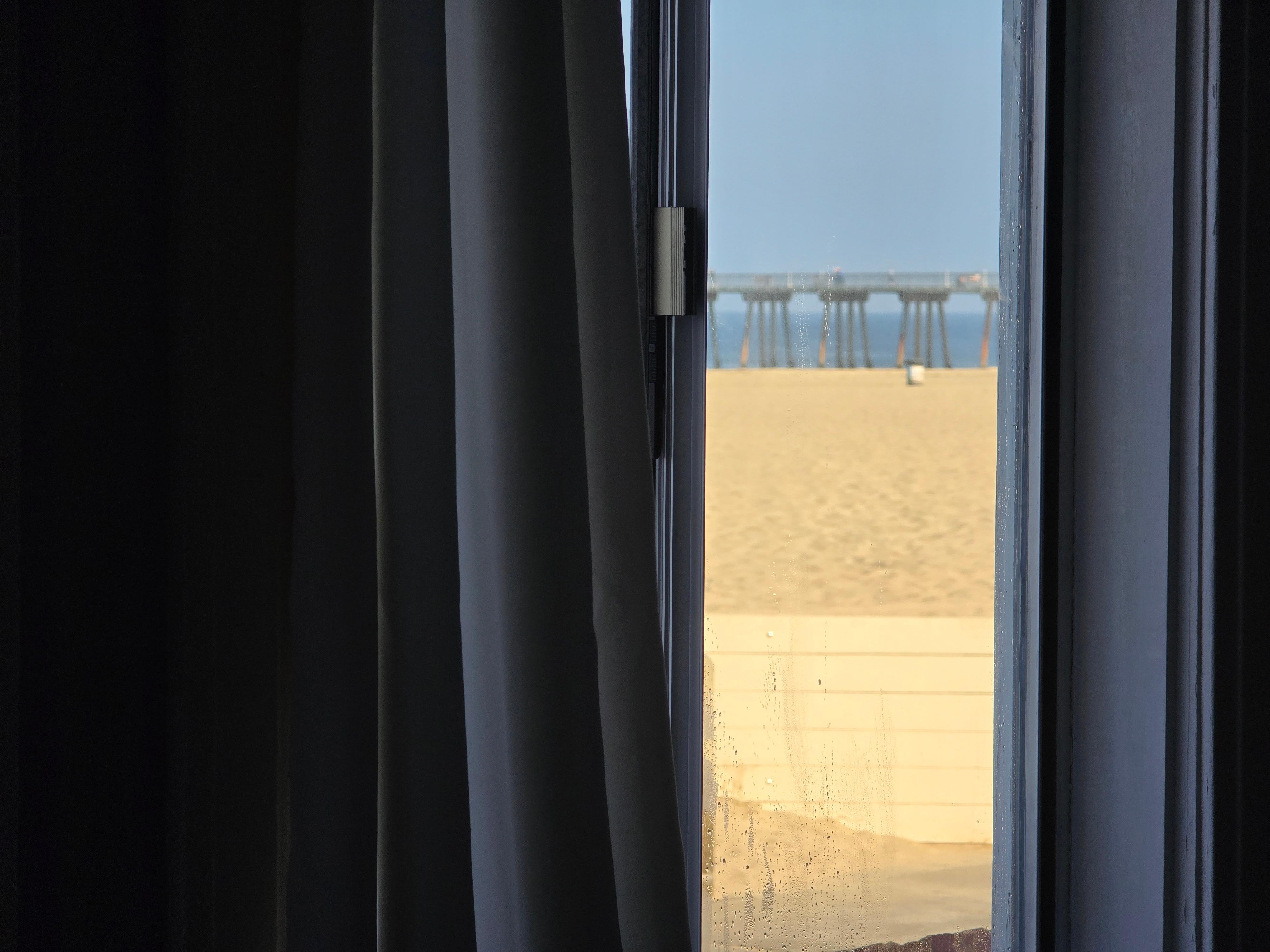 View of window looking a beach and pier.