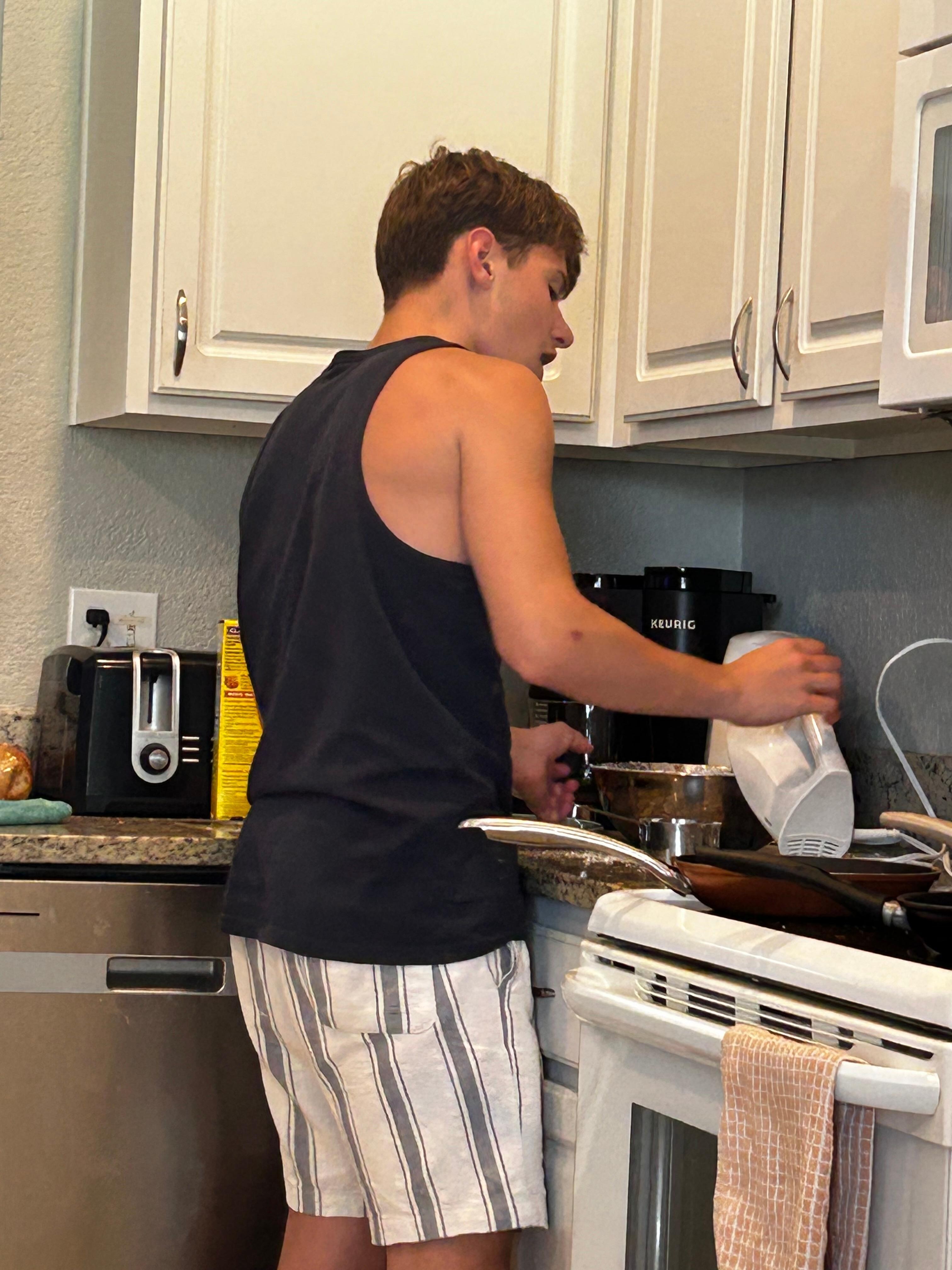 Grandson preparing pancakes for my birthday lunch at the house .
