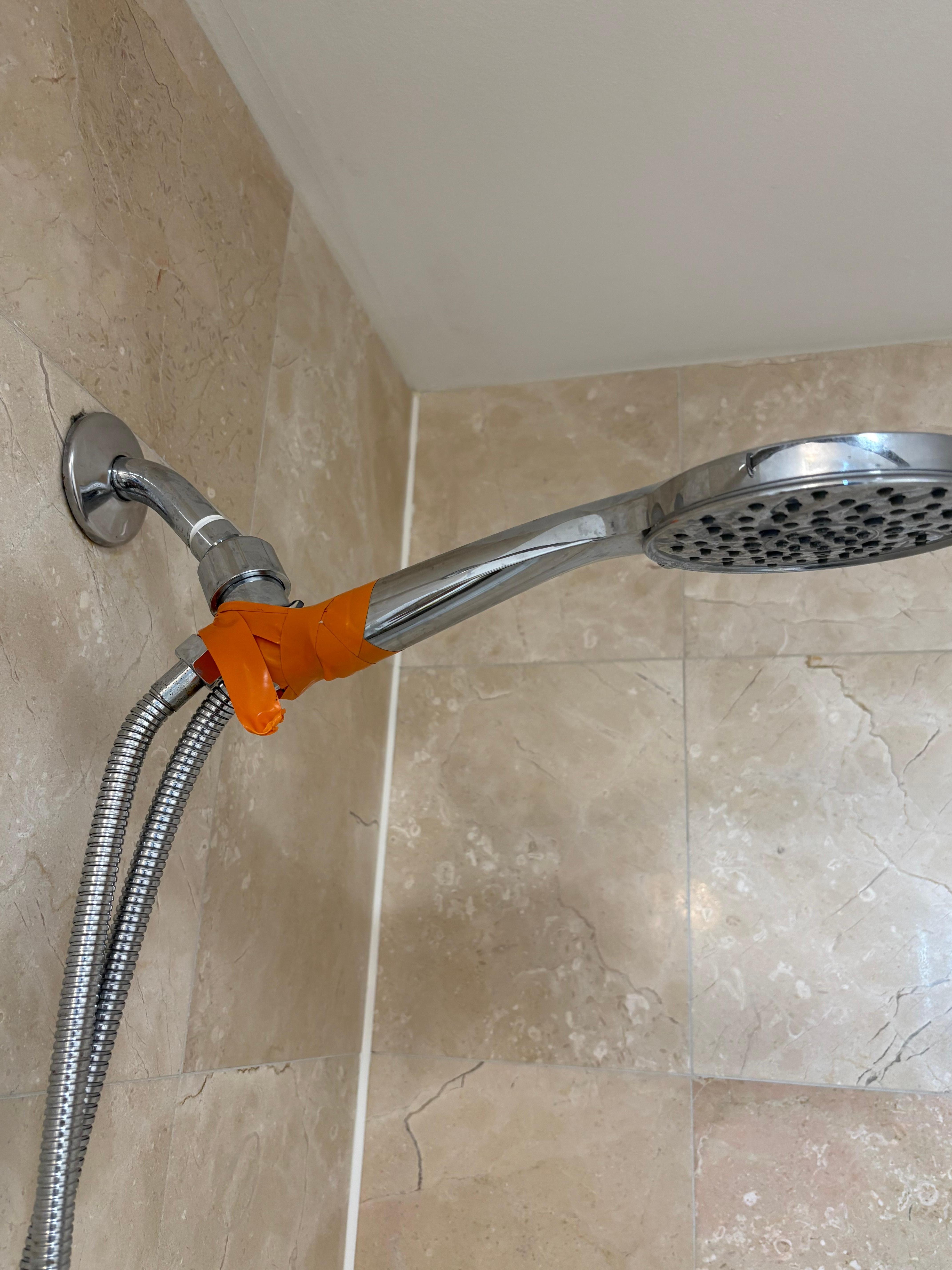 Broken shower hose held by tape.