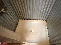 Rust at bottom of corrugated steel shower walls