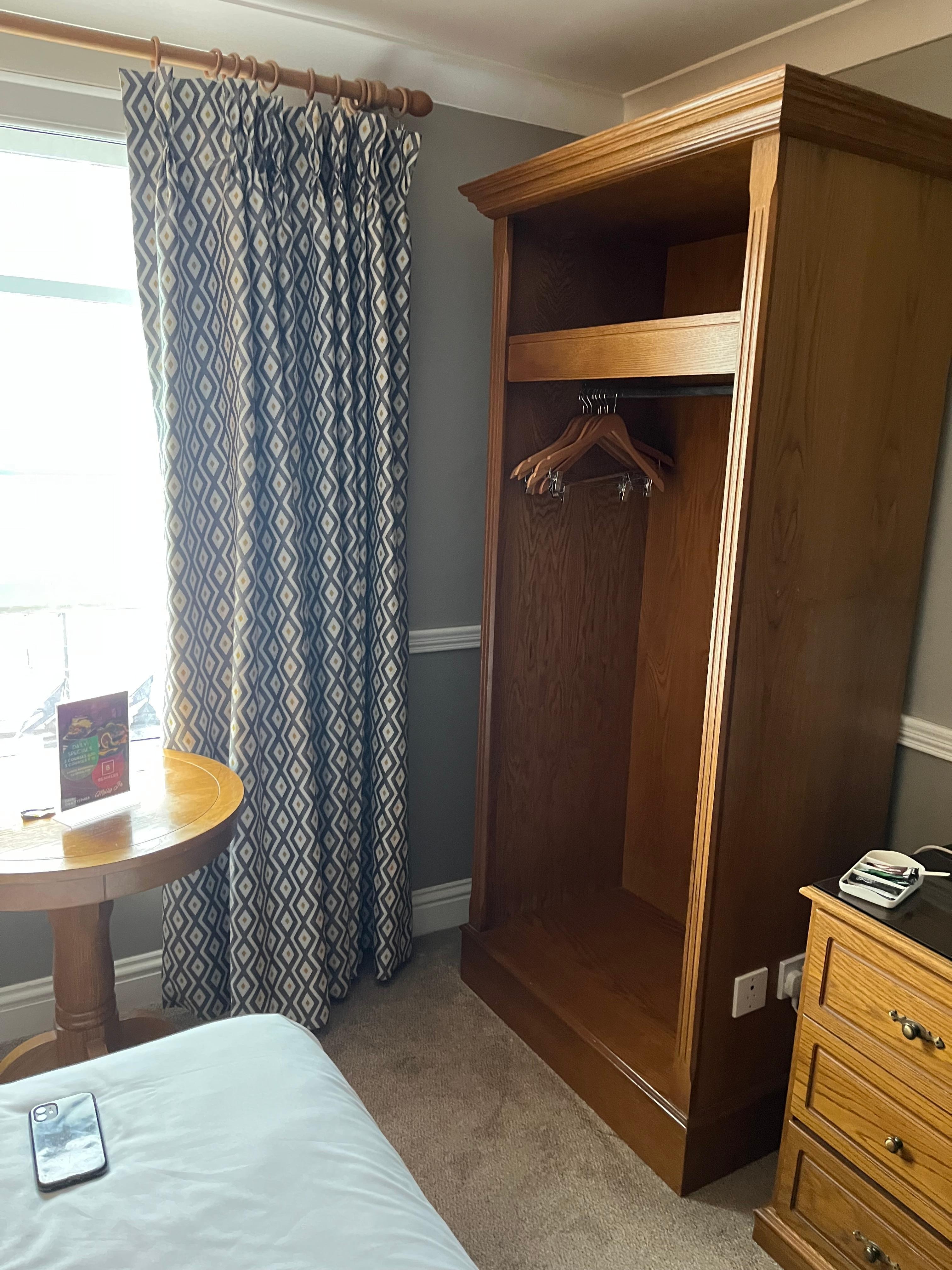 Cramped bed area with table and chair blocking that side of the bed