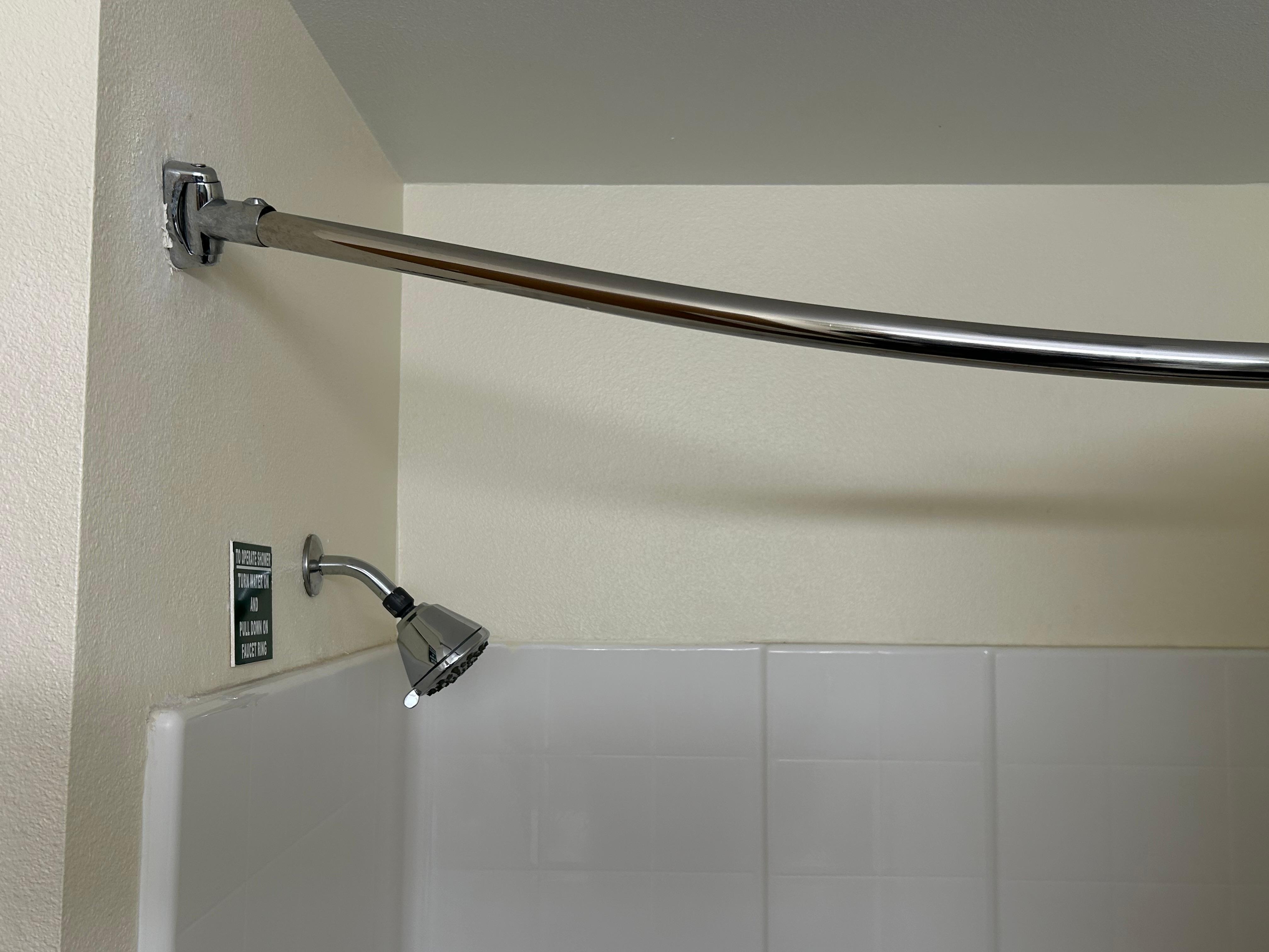 Shower curtain mounted at an angle preventing shower curtain from staying closed