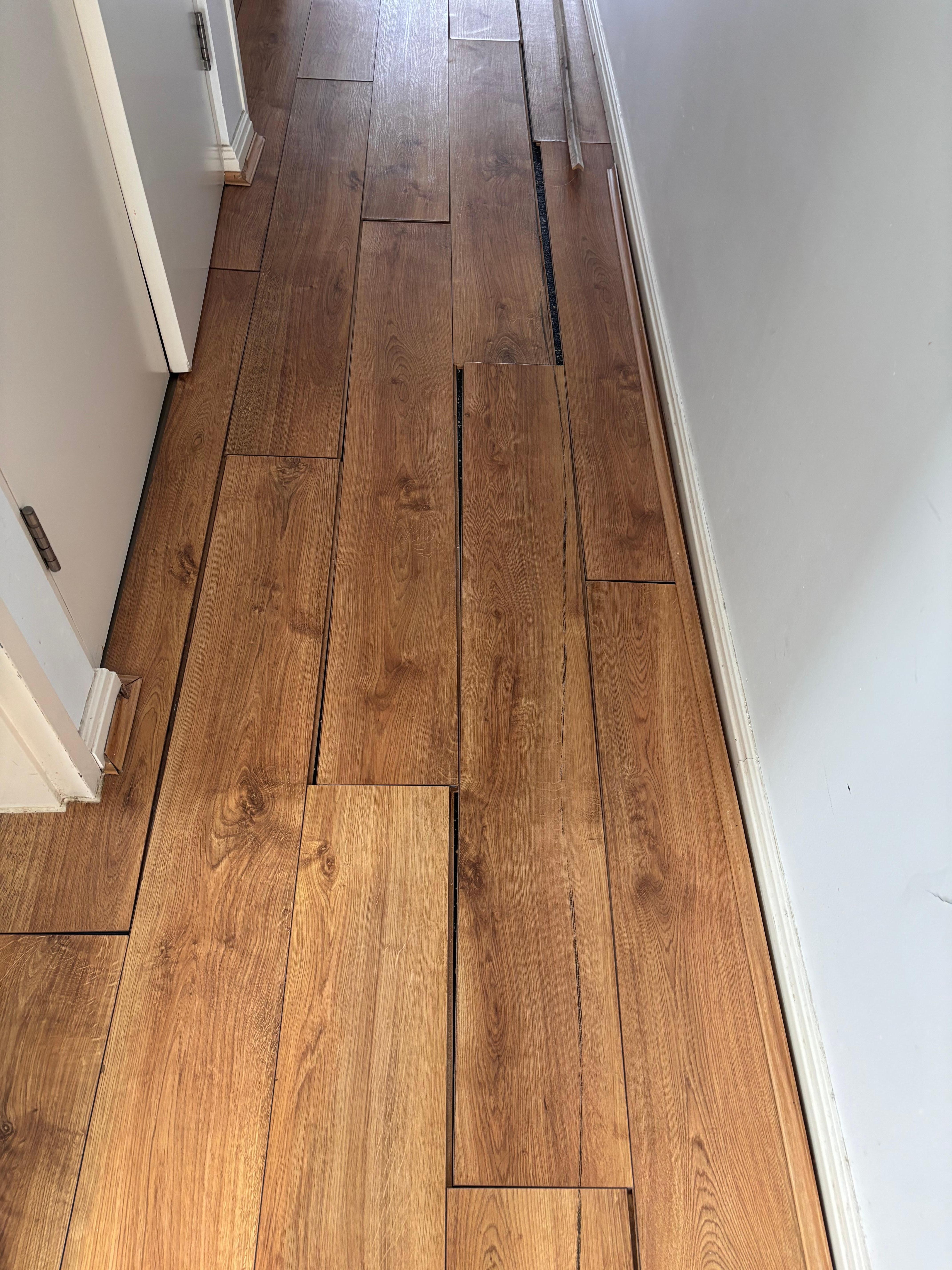 The floor in a state of disrepair. Big gaps between the laminate and the skirts on edge were  loose and away from the wall. 