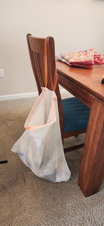 Trash bag with garbage in it on dining room chair, found upon our arrival. Gross.