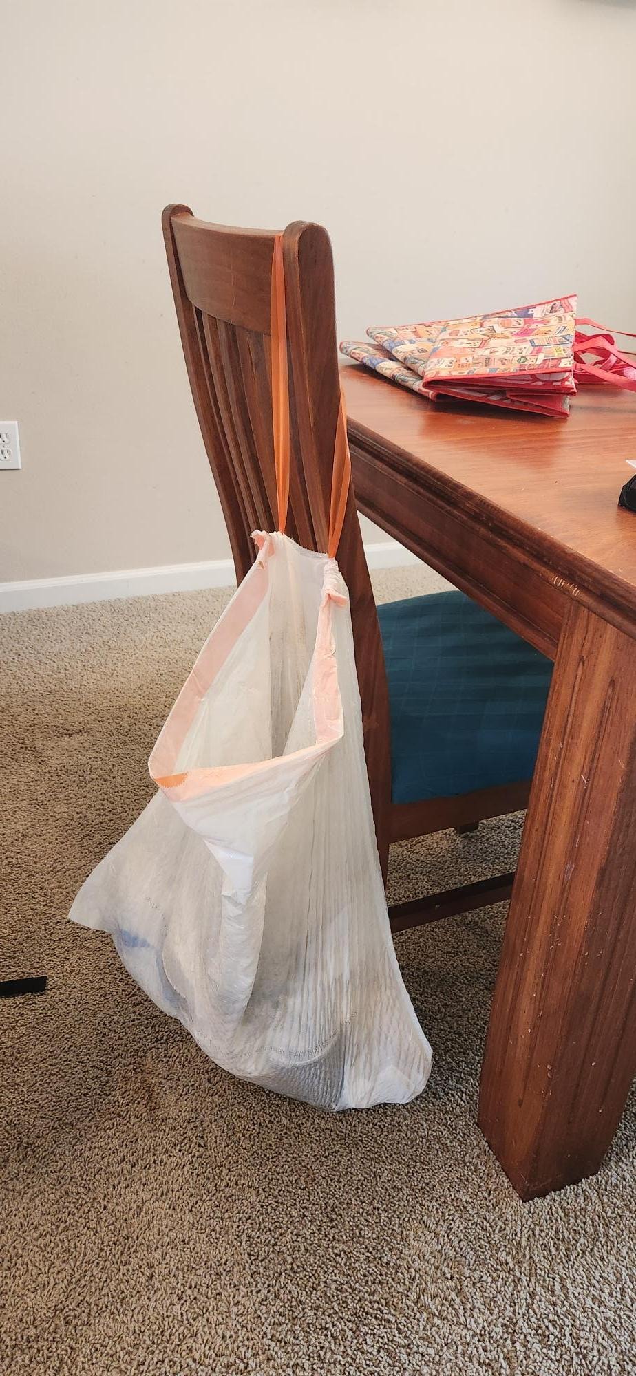 Trash bag with garbage in it on dining room chair, found upon our arrival. Gross.