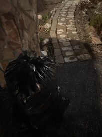 Trash bags right outside the property in the designated parking spot