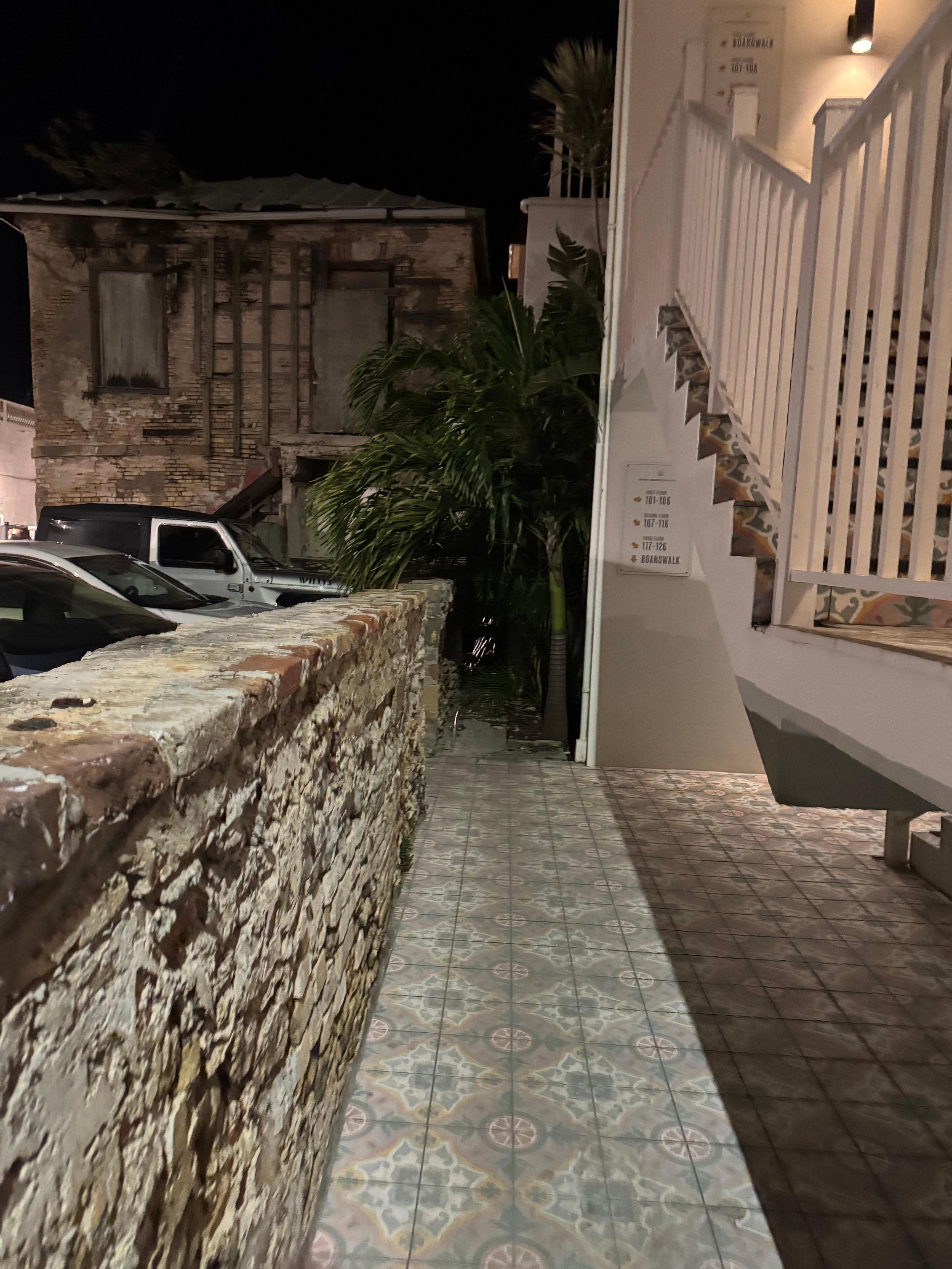 Dark pathway with parking lot with construction site and loading area (maybe)