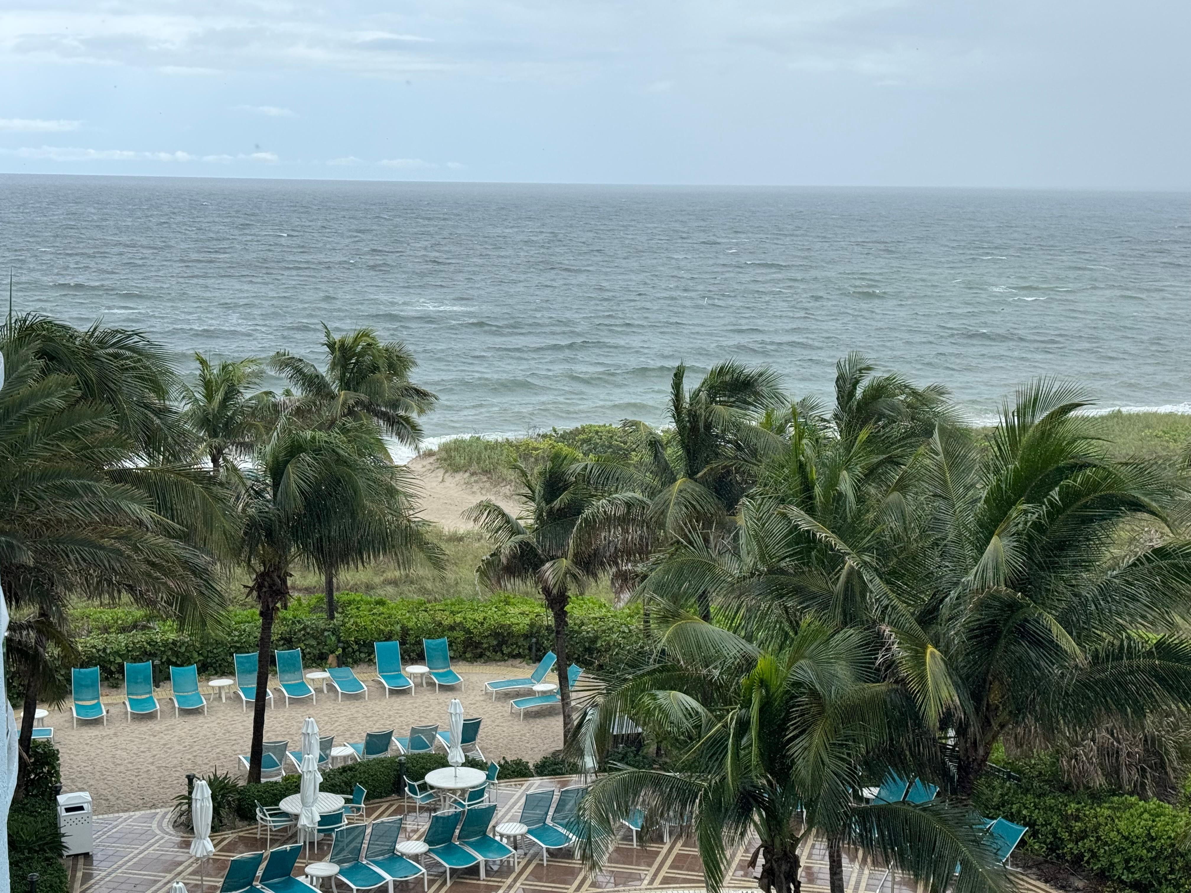 Pool chairs and the ocean in background 
