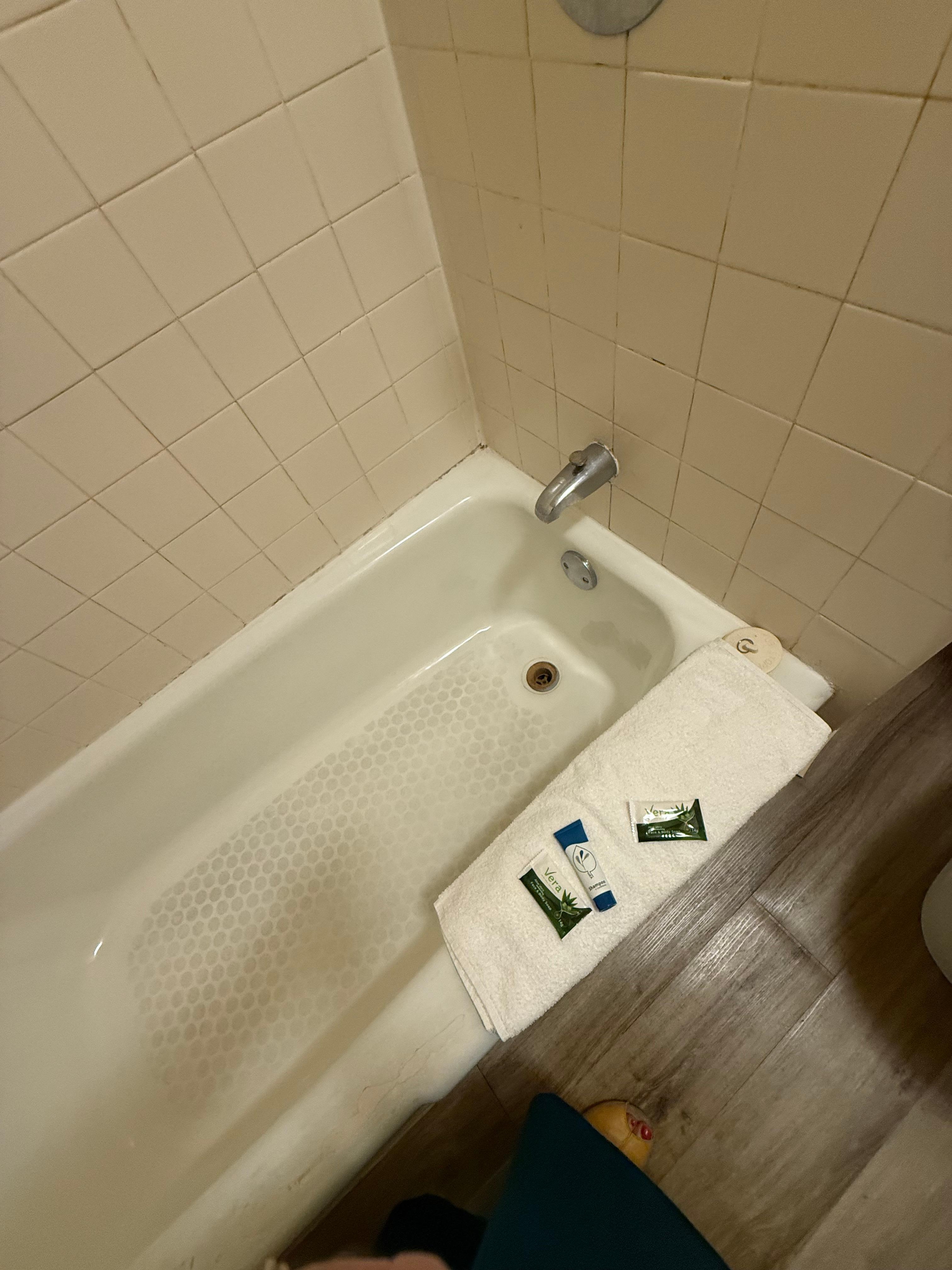 Edge of the tub had been repaired with dingy caulking. Moldy! 