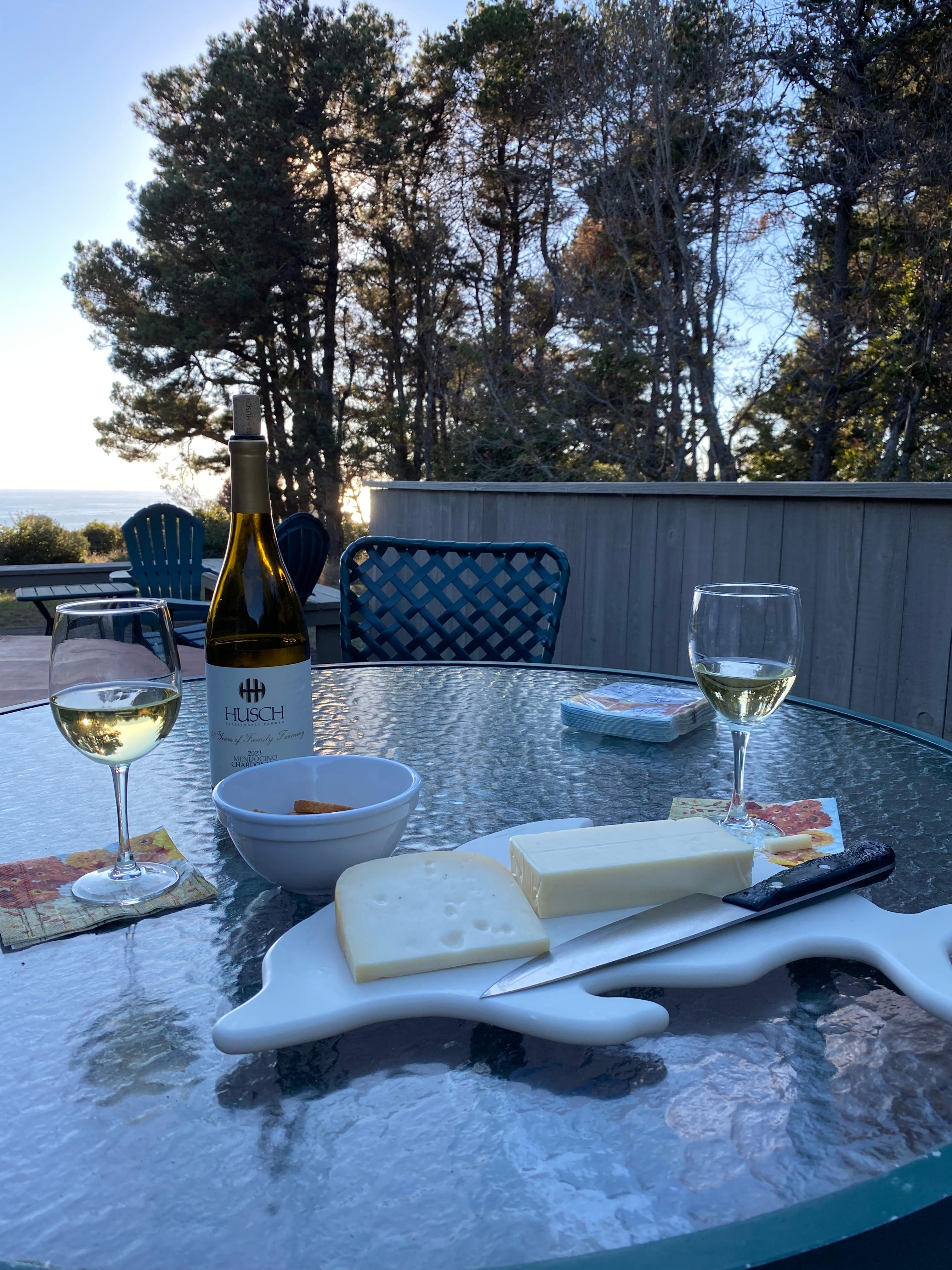 Cheese board on the porch overlooking the hot tub, yard, and Pacific Ocean.