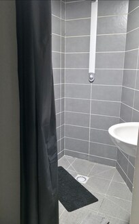 a plastic curtain separates the room from the toilet and shower