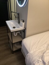 Very small sink in the very small hallway out side the very small bathroom