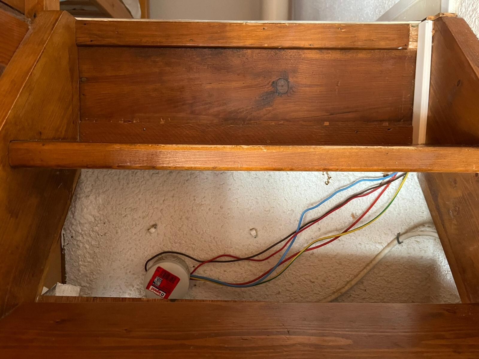 Kabel aus der Wand unter der Treppe