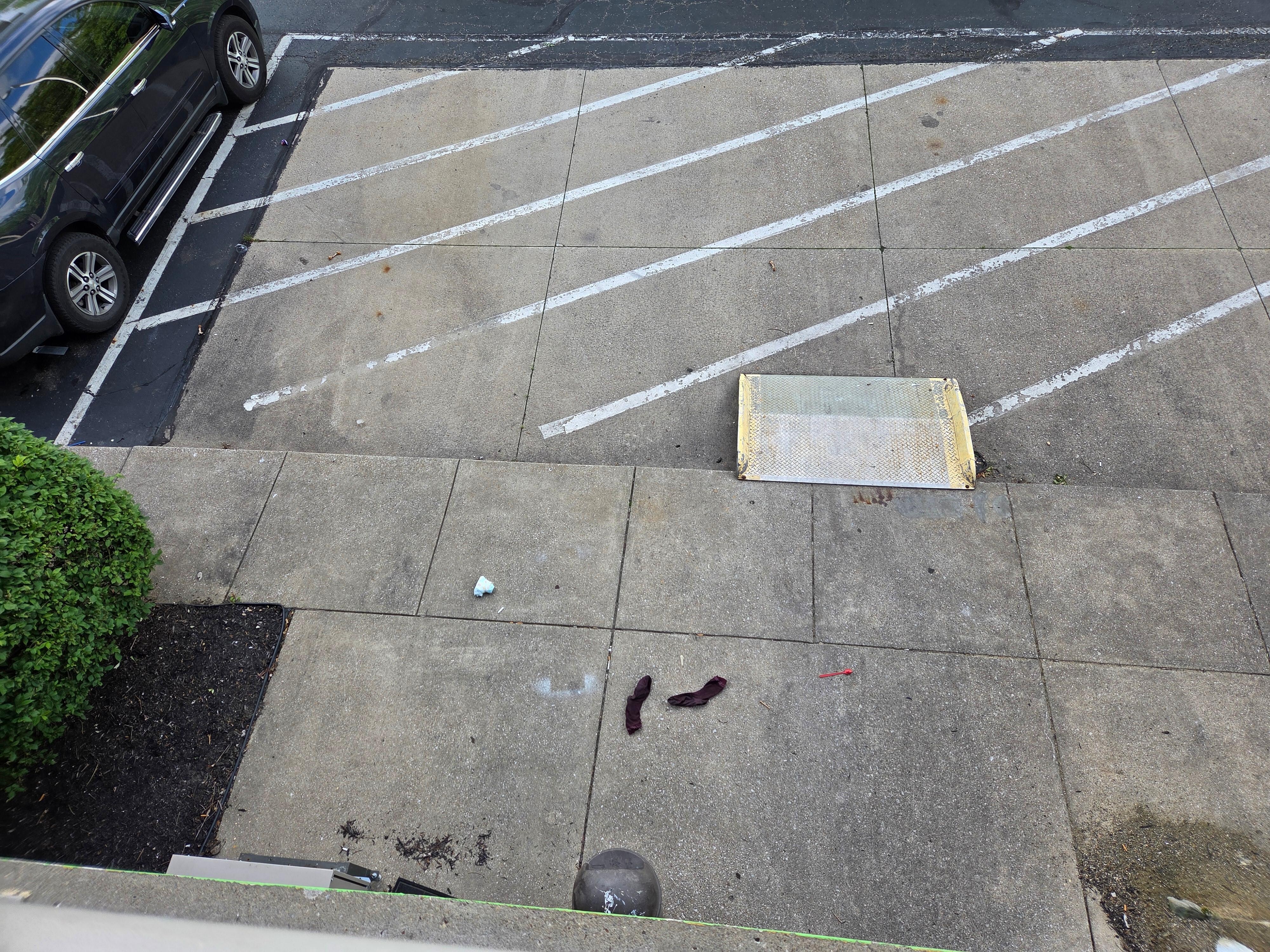 Diaper and socks on the parking lot floor. Do you see the trail of chicken bones?