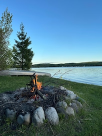 Big fire pit with woods beyond to gather firewood