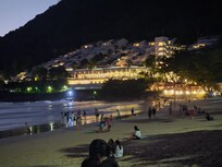 A view of The Nai Harn as seen at night from the beach