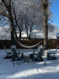 Spacious backyard with a hammock and chairs. Great for gathering.