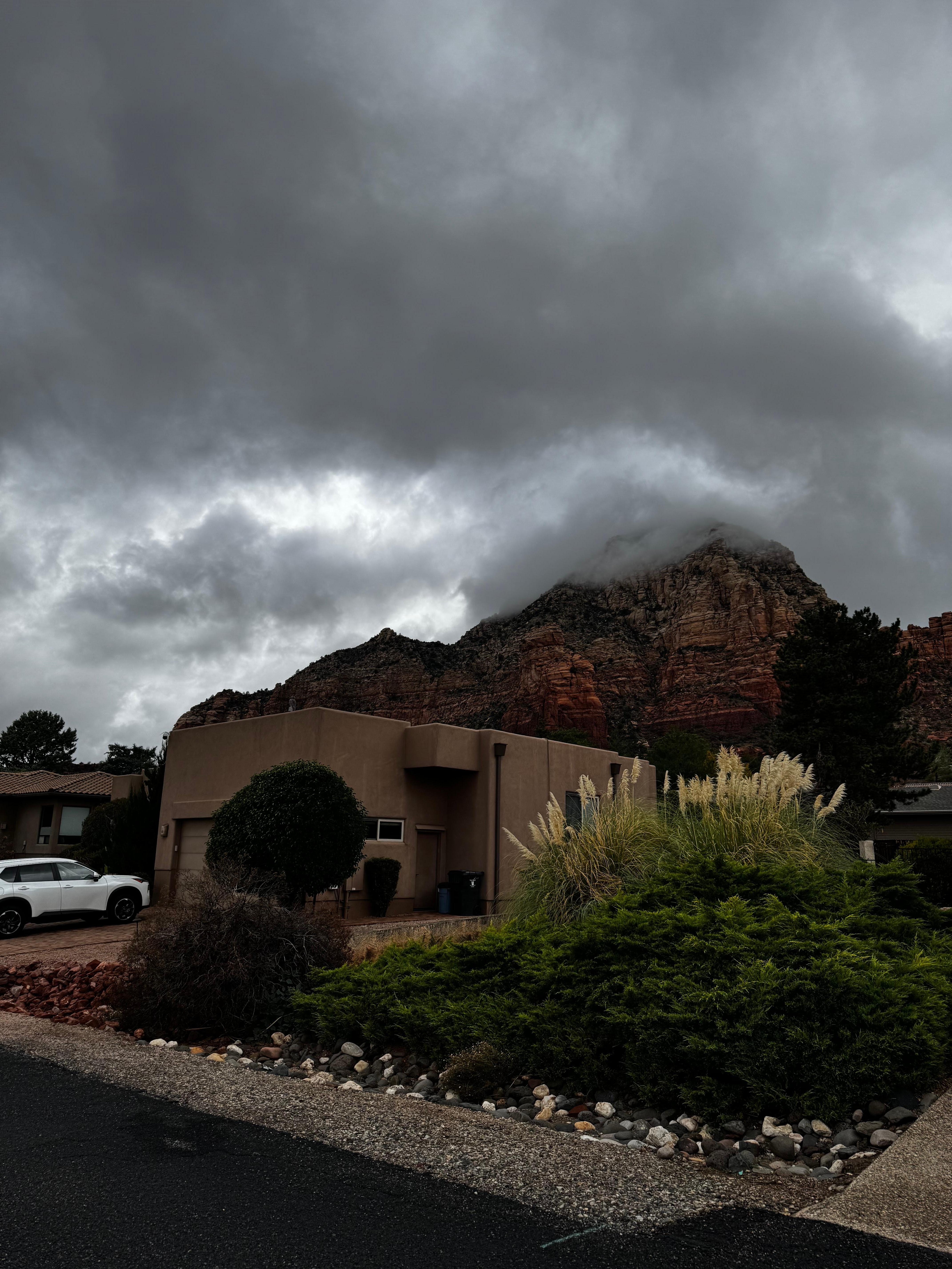 The house from the front with red rocks as the backdrop. 