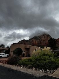 The house from the front with red rocks as the backdrop.