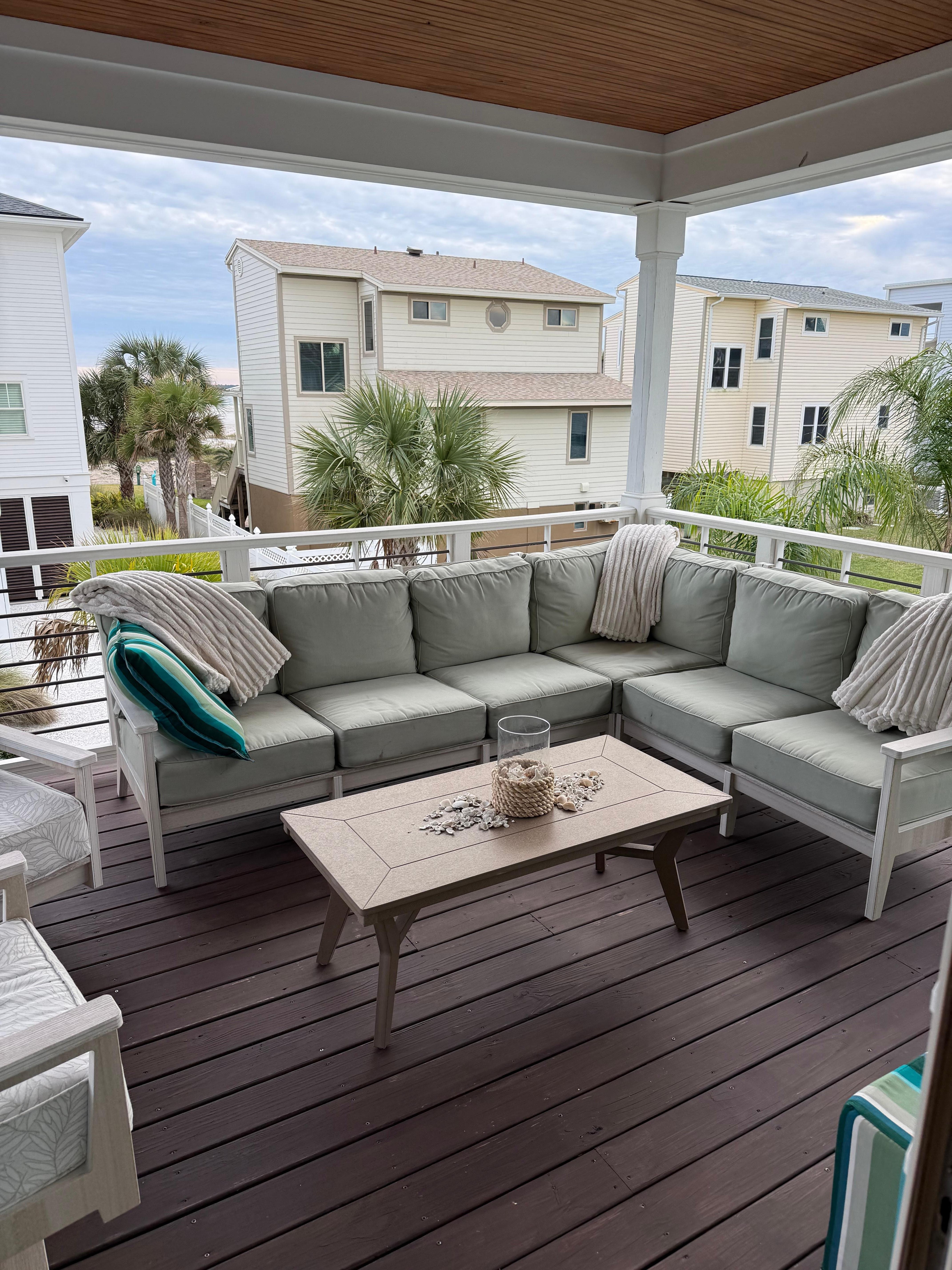 The back balcony is a comfortable area to relax with a partial view of the beach. 