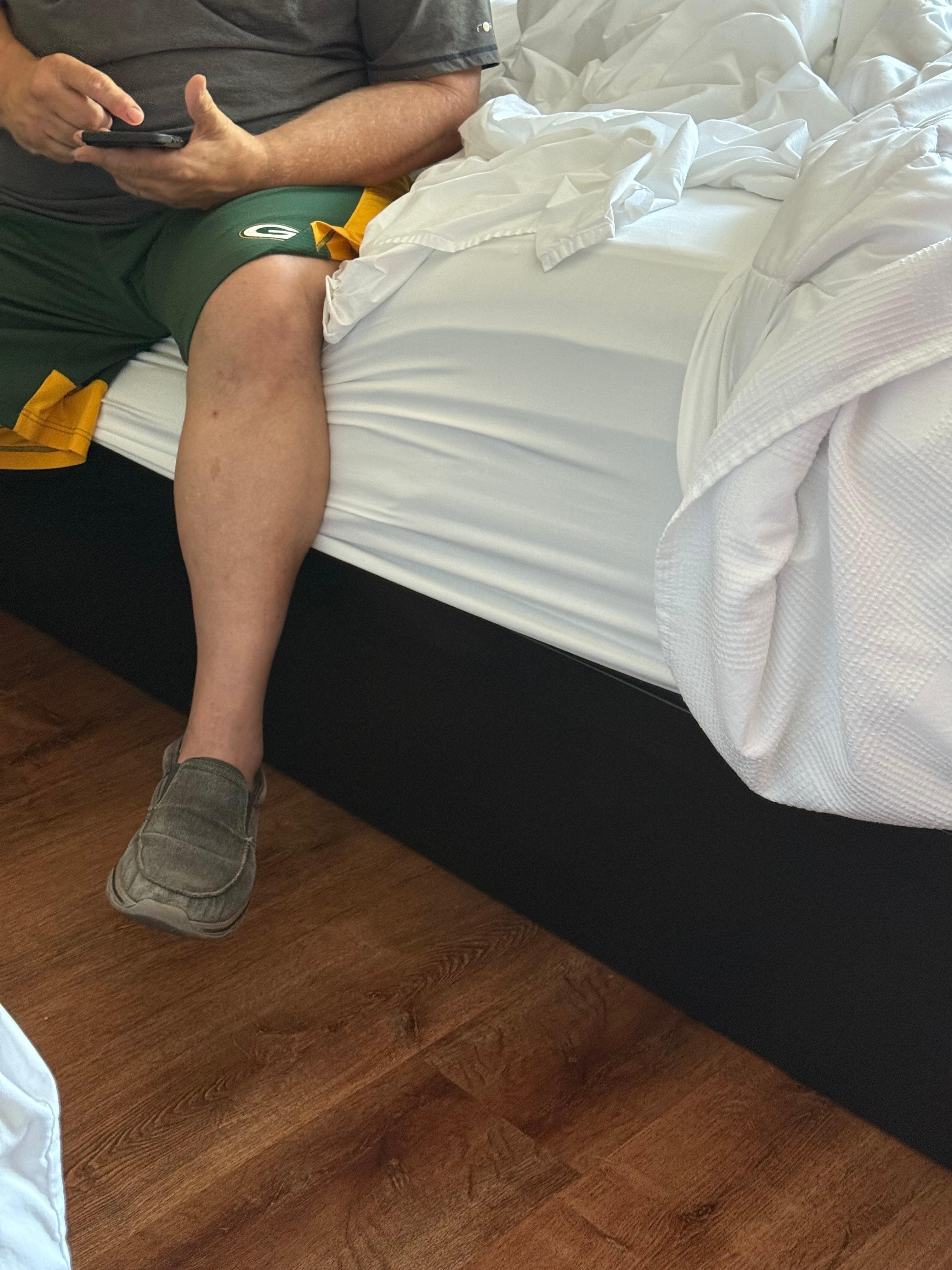 6 foot 3 adult sitting on bed edge