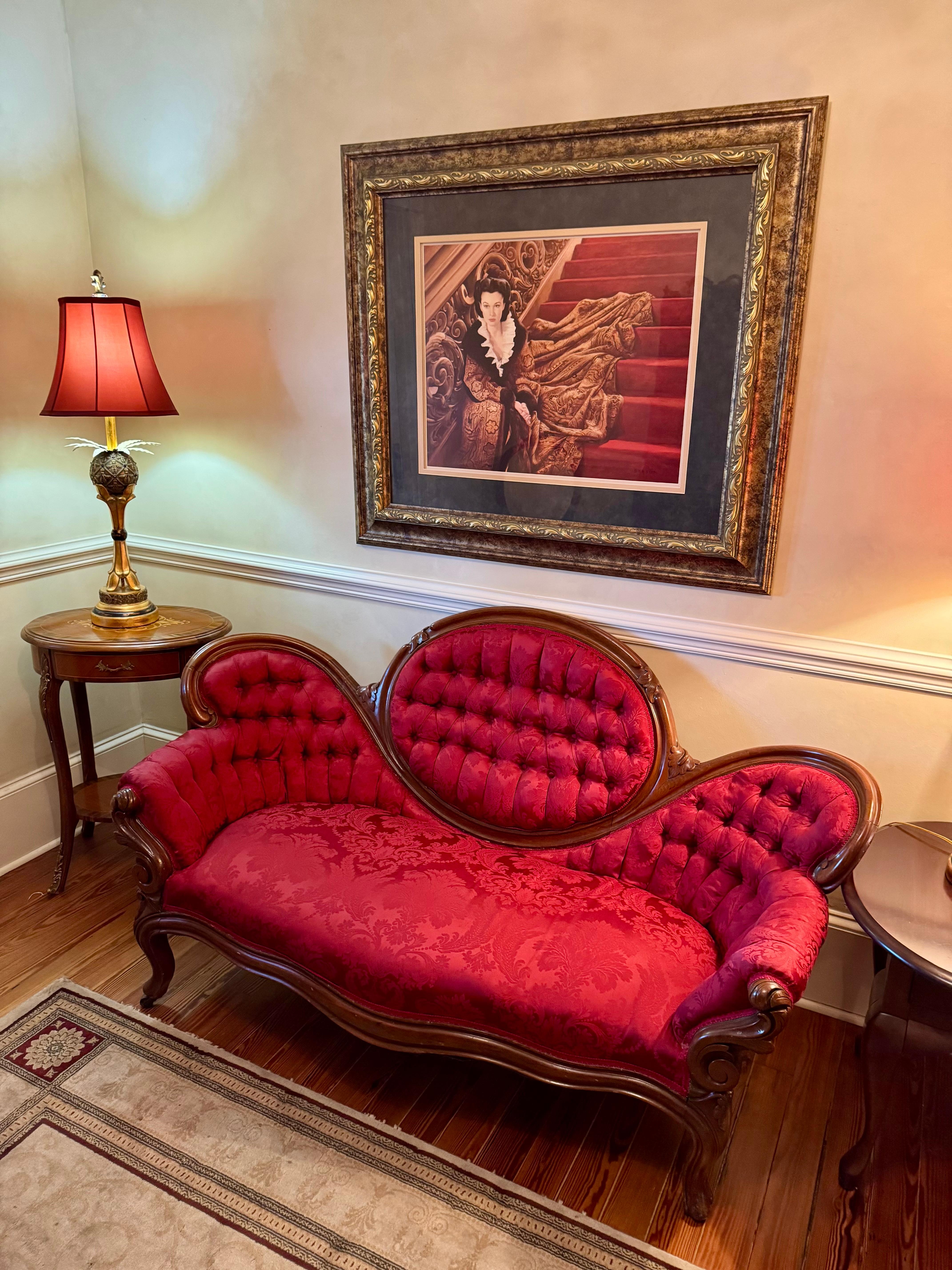 Beautiful red velvet couch and Vivian Leigh painting upstairs in The Hotel Magnolia Bed & Breakfast in Foley, Alabama 