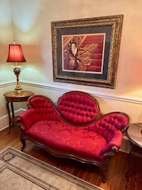 Beautiful red velvet couch and Vivian Leigh painting upstairs in The Hotel Magnolia Bed & Breakfast in Foley, Alabama