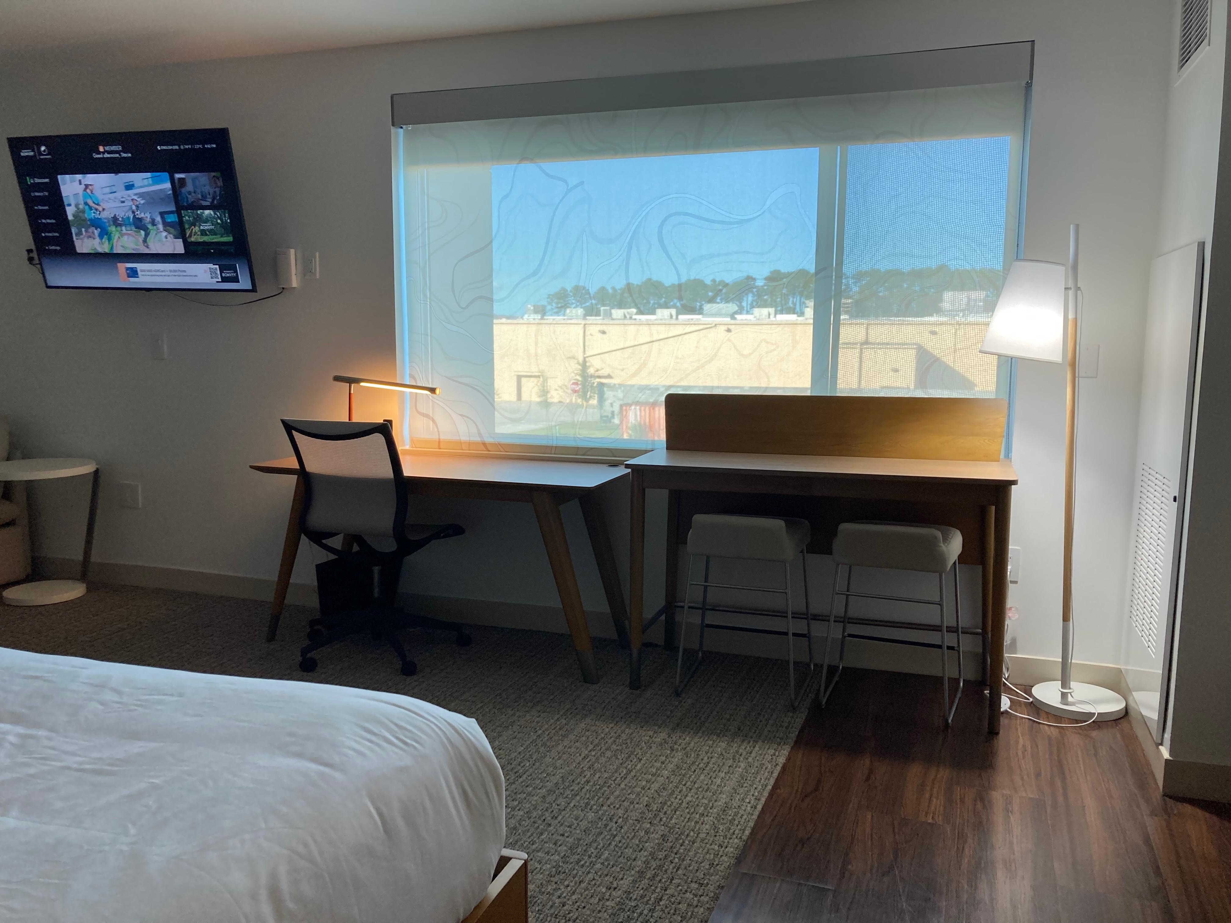 Nice sitting area with lamp and an additional barstools and table.