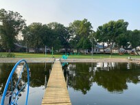 Clear water, sandy beach, and extensive lawn.