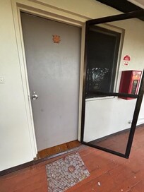 Broken screen door at the entrance to our room