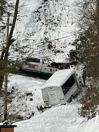 The bus stopped by a rock.