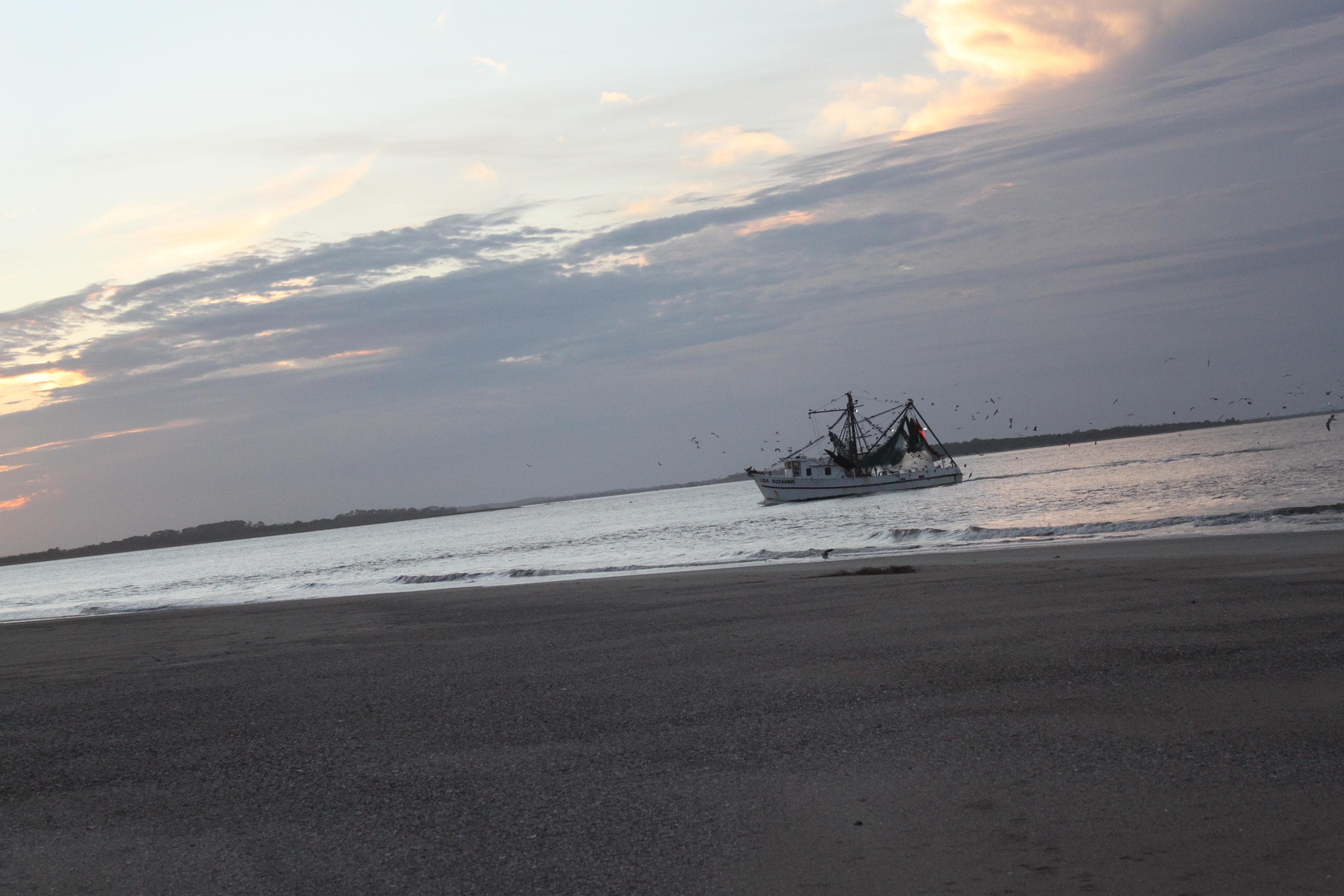 View from the Beach of incoming shrimp boat