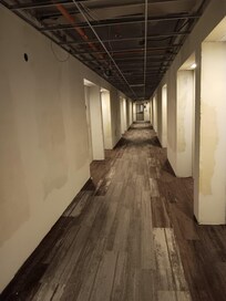 Hallway with wires hanging down under construction, lights hanging down. Very bad and dangerous