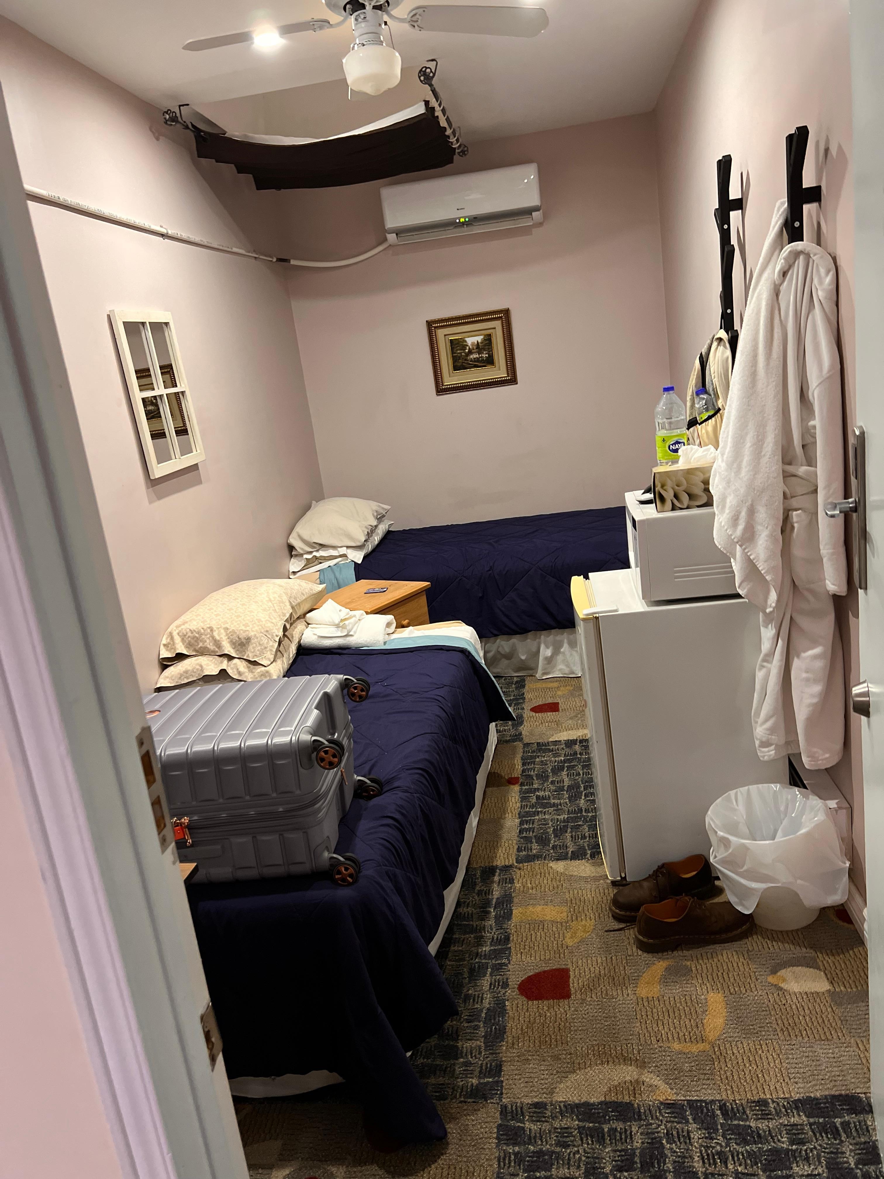 This is the room they call a deluxe accommodation note the blanket hanging over the broken skylight. The open pipe from the air conditioner over the bed. I’m lucky it didn’t leak on me. The room smelled, and there were cigarette burns in the blanket 