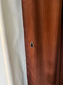Holy smokes. One of many cigarette burns in the curtains.