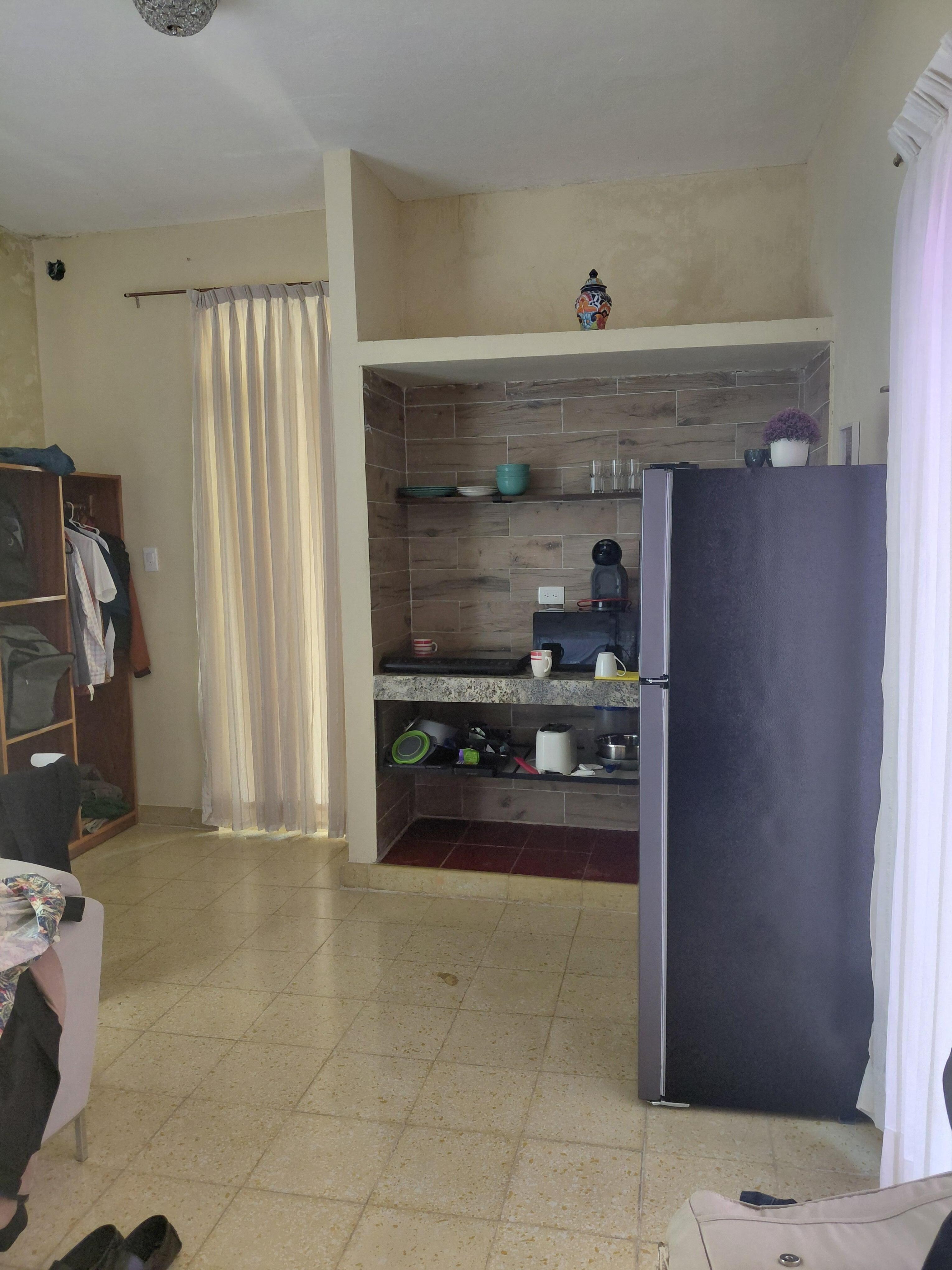 "SUITE WITH KITCHEN AND LAUNDRYZ" is a single room with a refrigerator and countertop with hotplate , next to the bed. There is no closet. 
c