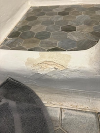 Entrance to shower, plaster coming off.