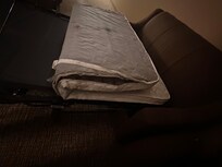 Side view of dirty pull out mattress, with large hole