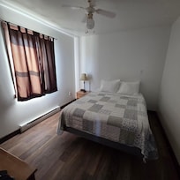 Chambre au rez de chaussé avec un lit queen