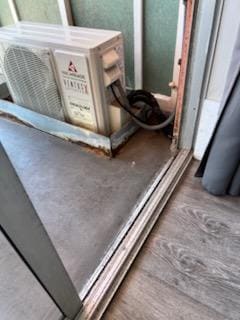 The old aluminum sliding glass door takes 2 people to slide open and then the condenser for the poorly installed mini split system is right in the walkway. Major tripping and safety hazard. Unit sits in an old rusty galvanized pan.
