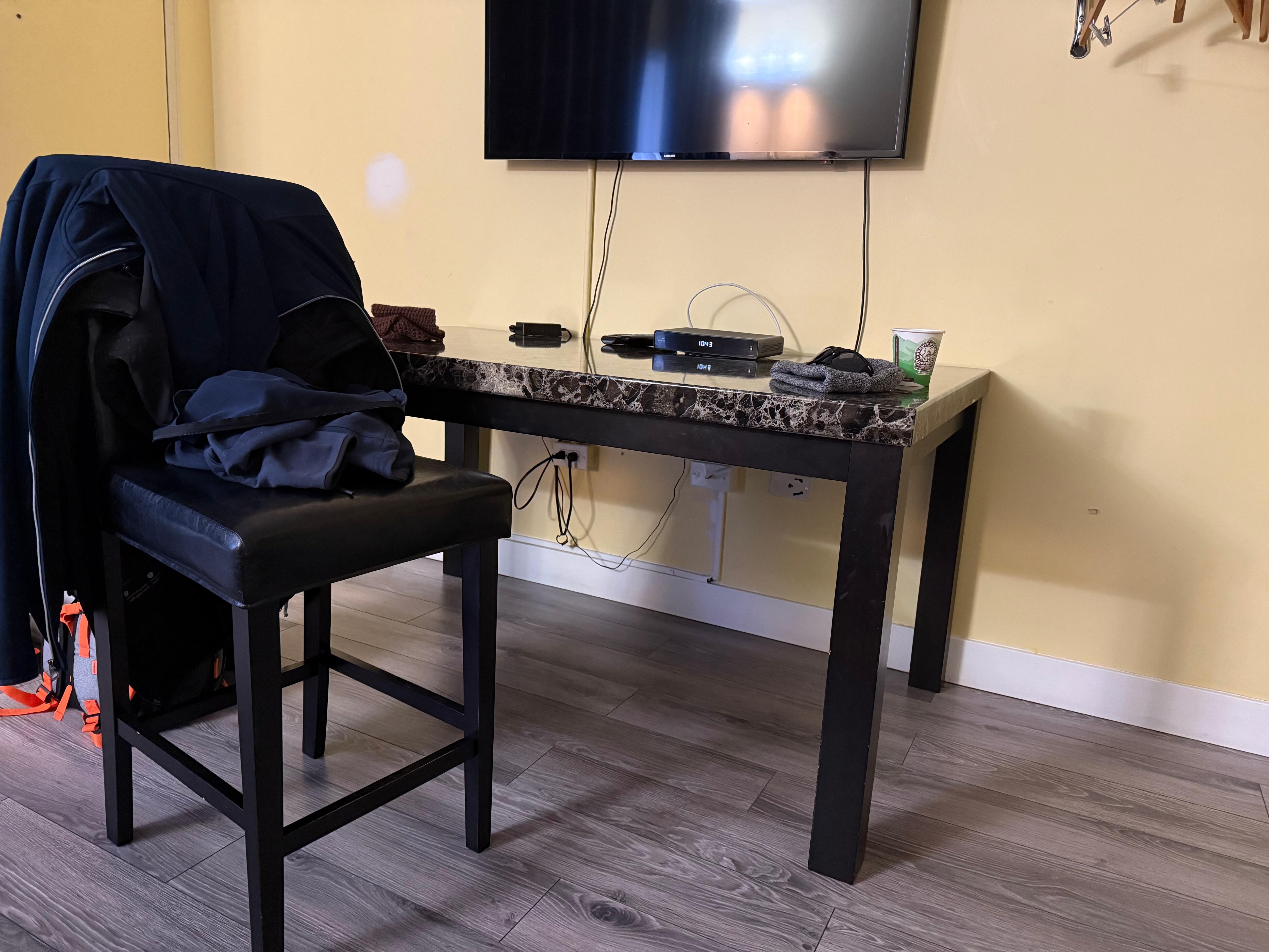 The only table and chair in the room, note the chairs bar height and you wouldn’t be able to sit facing the table with this chair. 