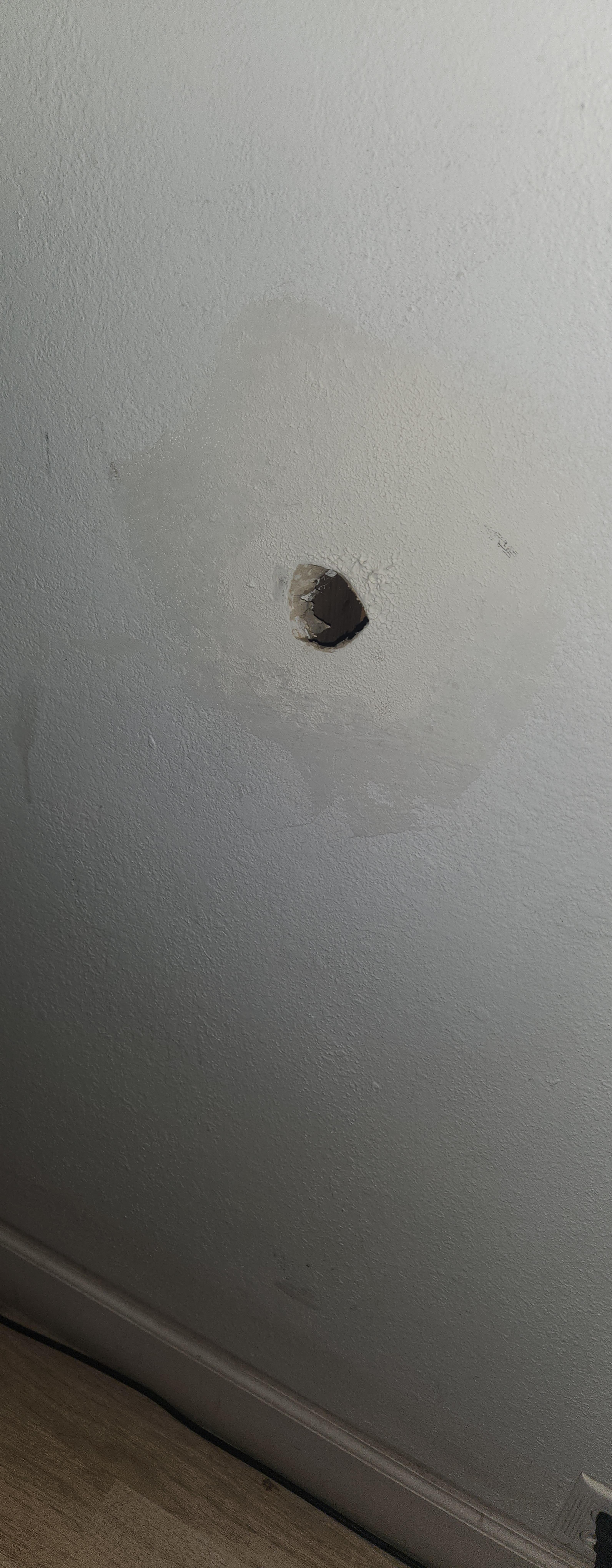 Hole in the wall behind the door