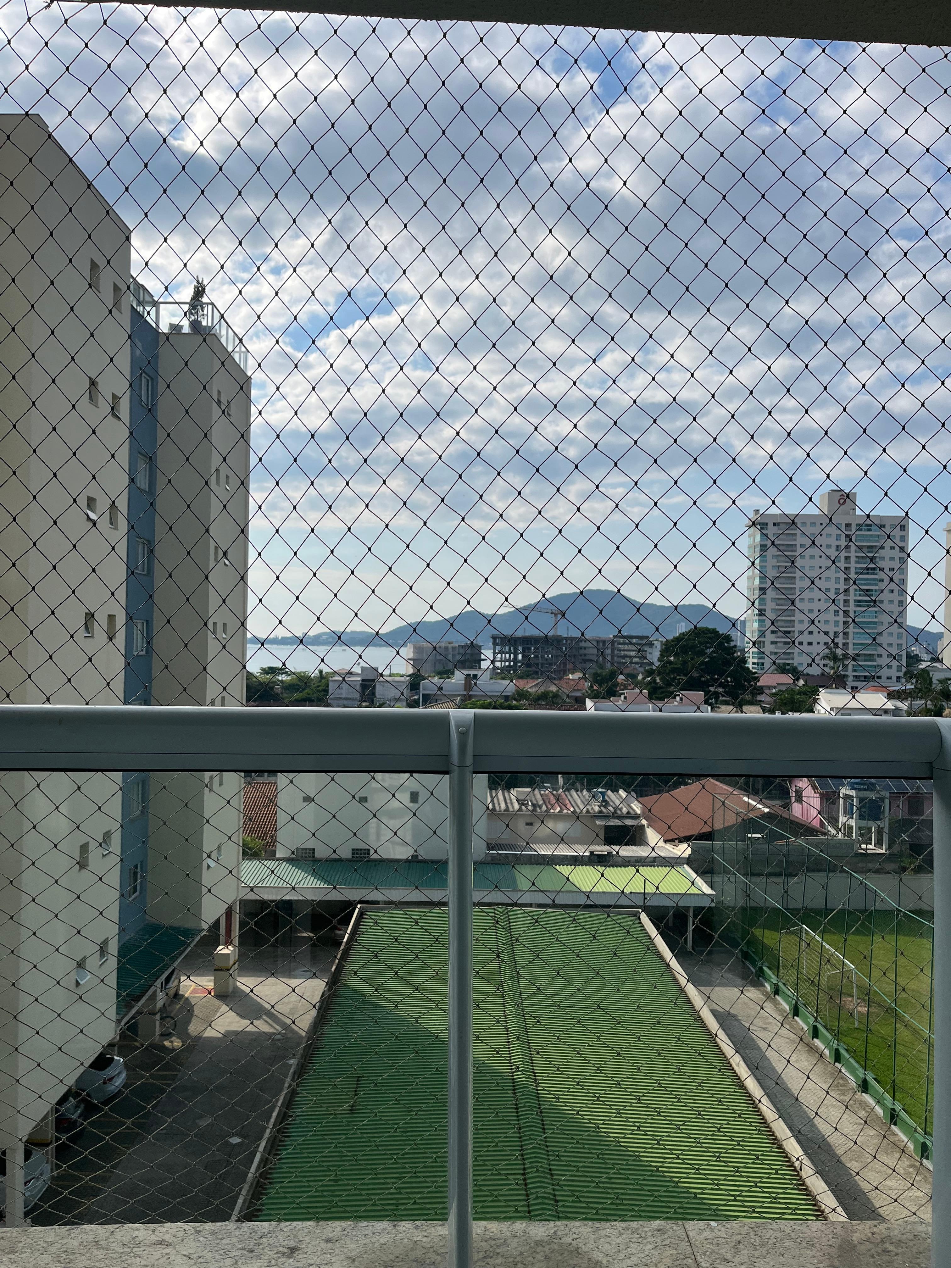Sentada na cama do quarto do casal olha a vista 