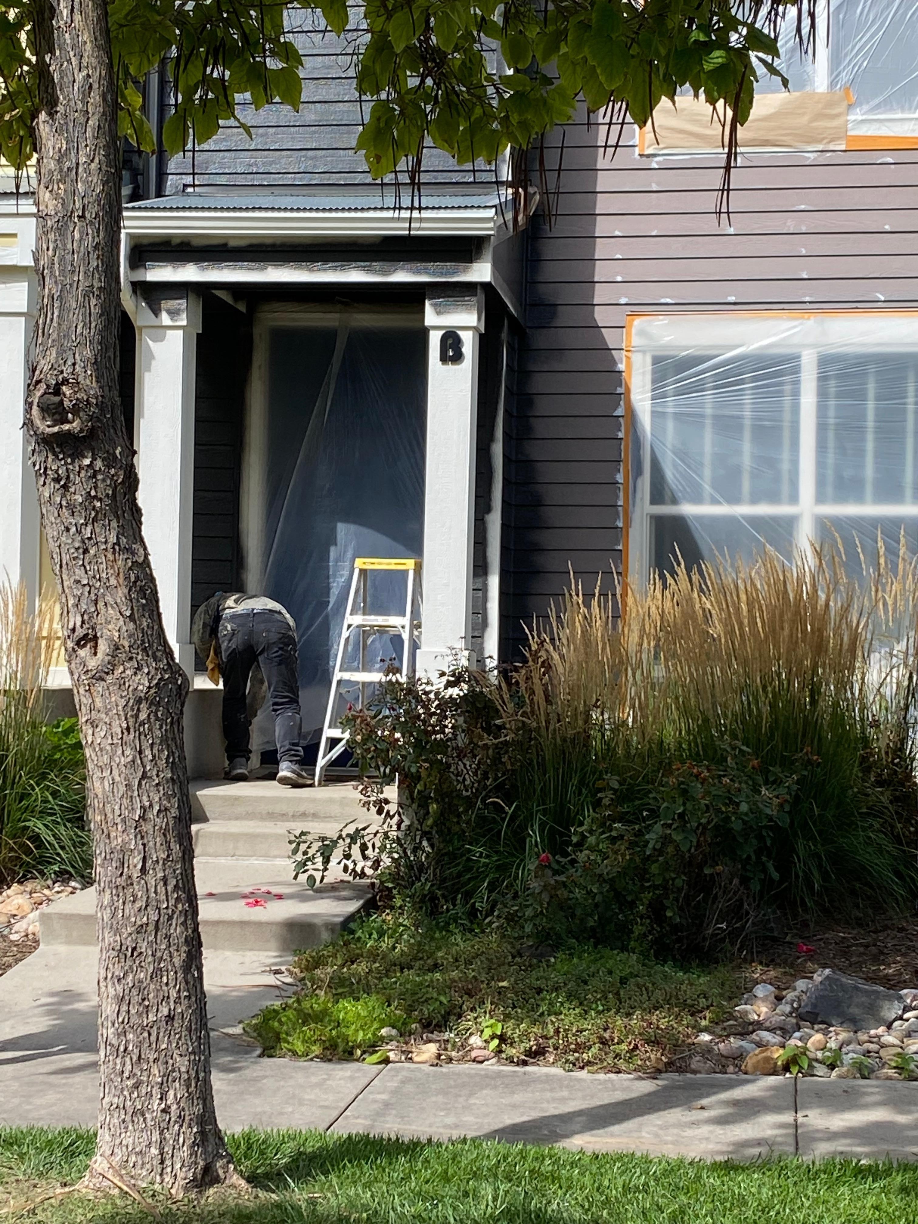 Worker moving plastic so we can get in our front door.