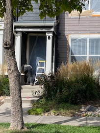 Worker moving plastic so we can get in our front door.