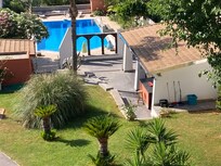 View onto pool from apartment including pool house/ outdoor kitchen area