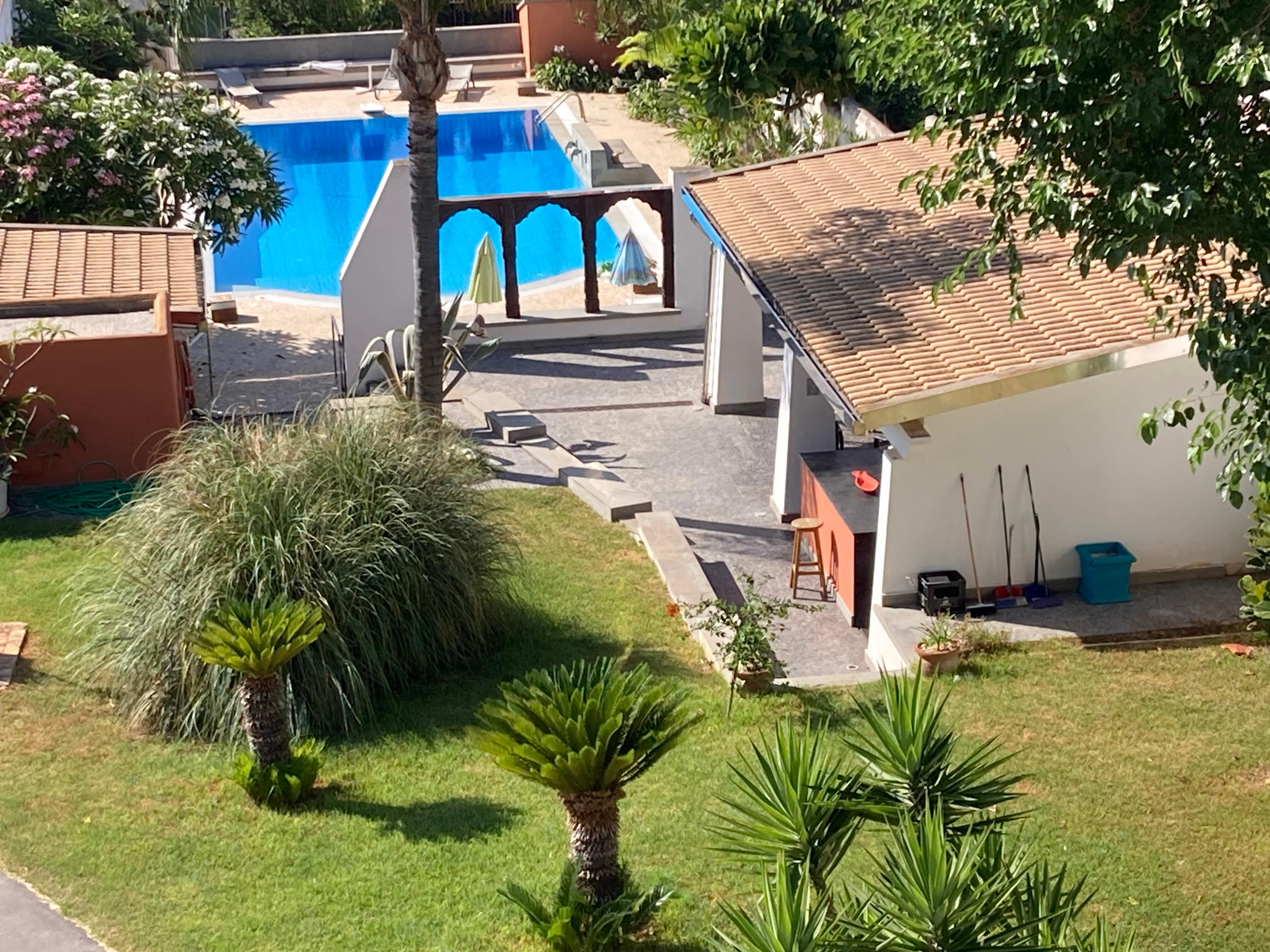 View onto pool from apartment including pool house/ outdoor kitchen area 