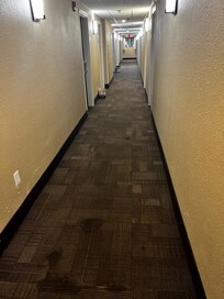 Hallway right outside our room with stained floor and beer in the hallway